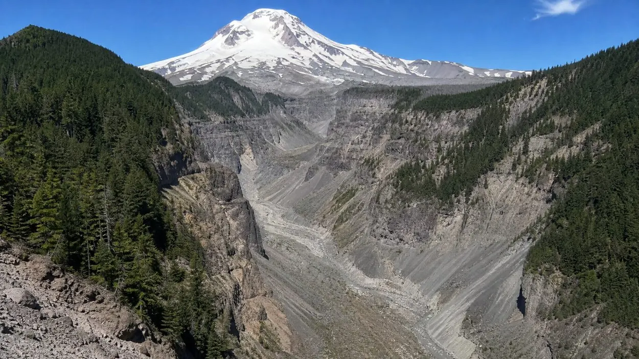 Un profondo canyon di detriti vulcanici grigi che solca il fianco del monte Hood